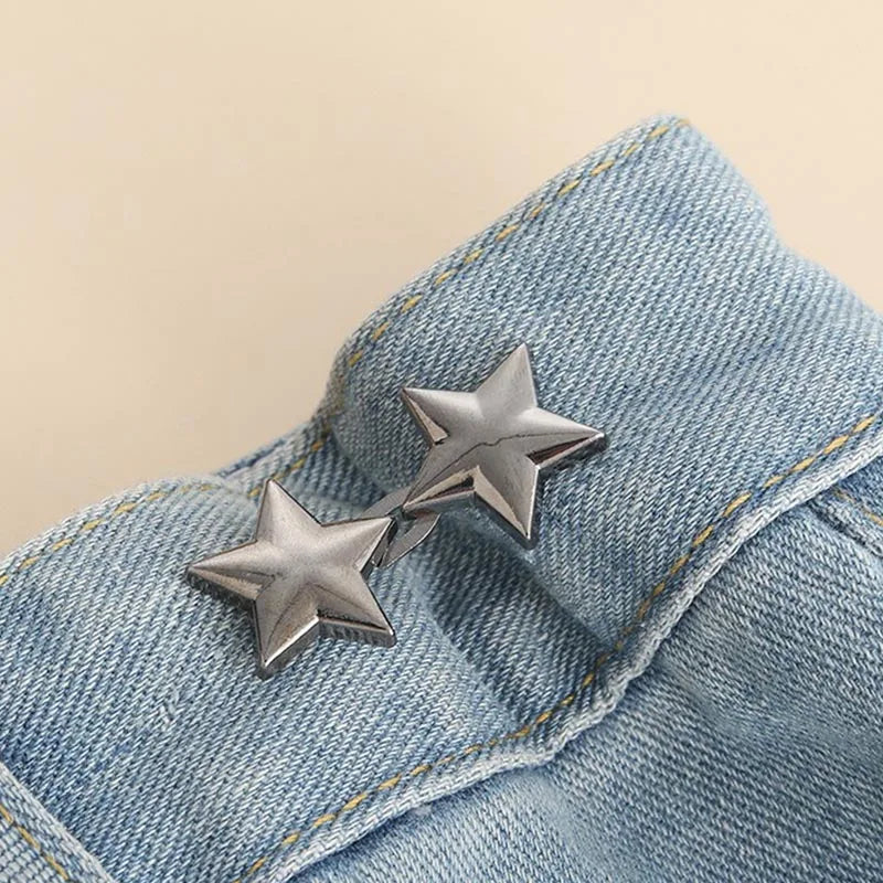 Silver star-shaped brooches clipped onto a light blue denim fabric