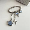 Silver keychain featuring a star-shaped pocket watch with a blue face and dangling charms.
