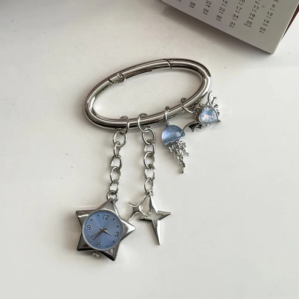 Silver keychain featuring a star-shaped pocket watch with a blue face and dangling charms.