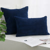 A dark navy blue corduroy striped throw pillow cover resting on a white surface.
