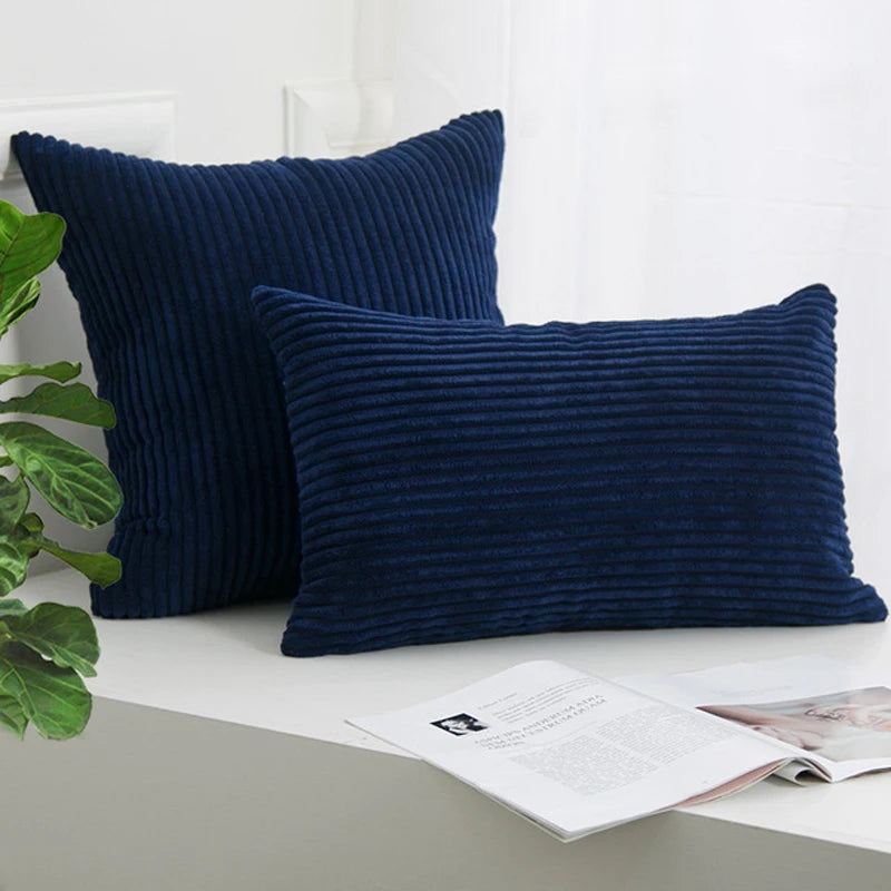 A dark navy blue corduroy striped throw pillow cover resting on a white surface.