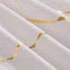 White fabric with gold wavy lines, showing a close-up of the texture and drape.