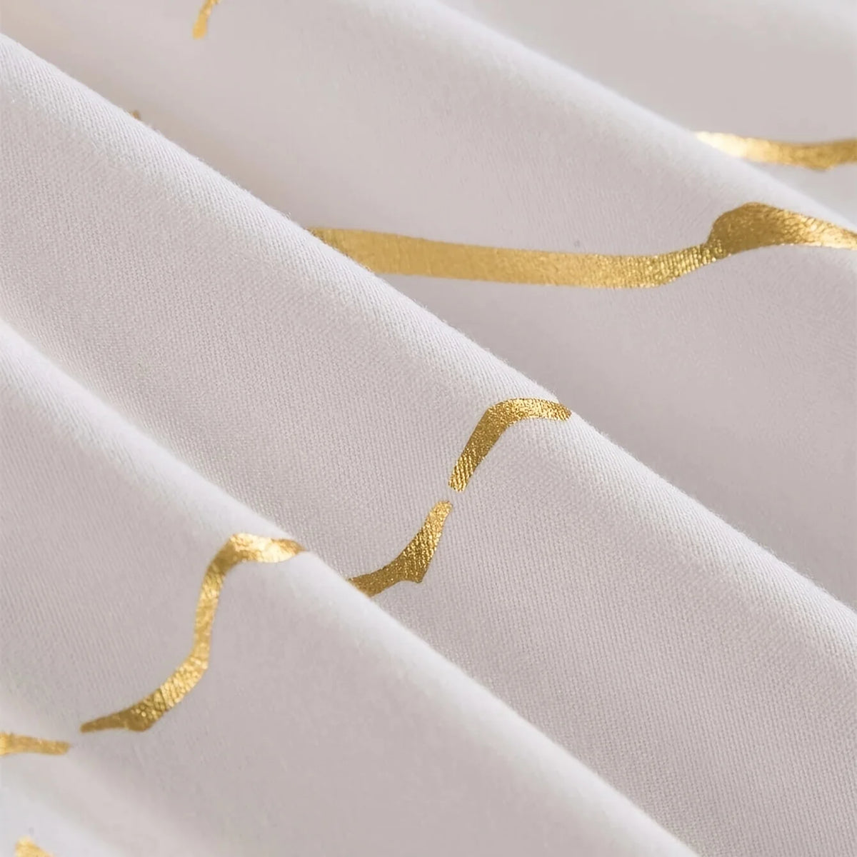 White fabric with gold wavy lines, showing a close-up of the texture and drape.