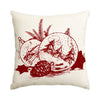 A red line drawing of a Christmas snowflake tree, pine cones, and a globe on a beige pillow cover.
