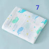 A white cotton muslin swaddle blanket featuring light blue and green sea creature designs.