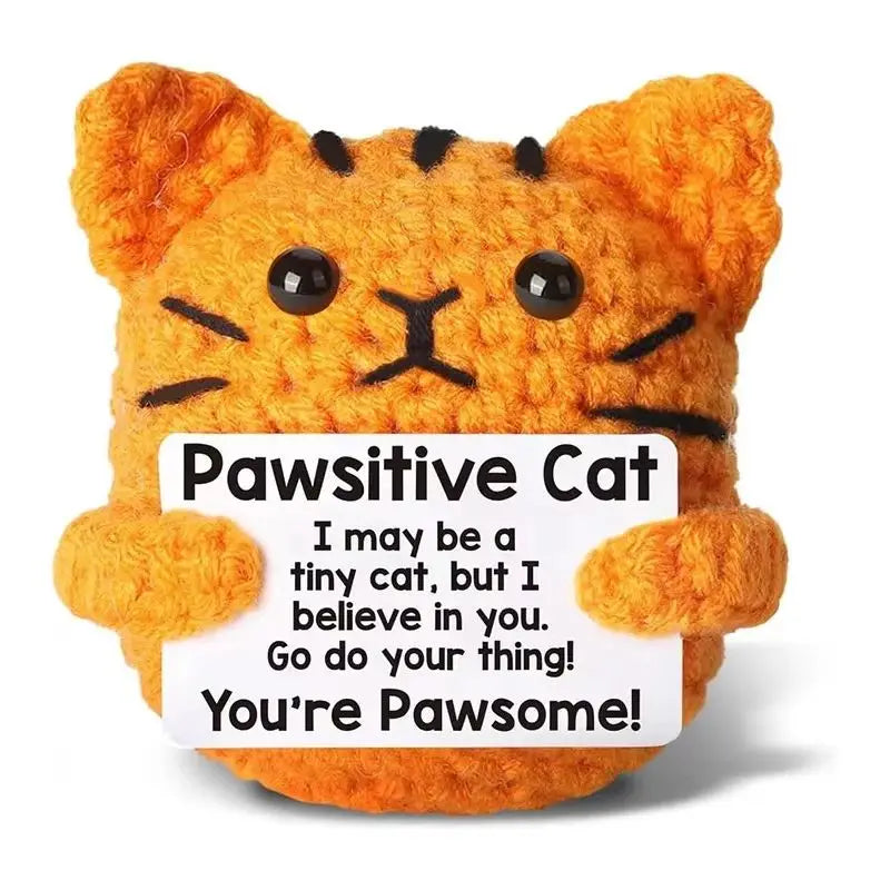 An orange fluffy cat plush toy with black stripes and a humorous text on the tag.