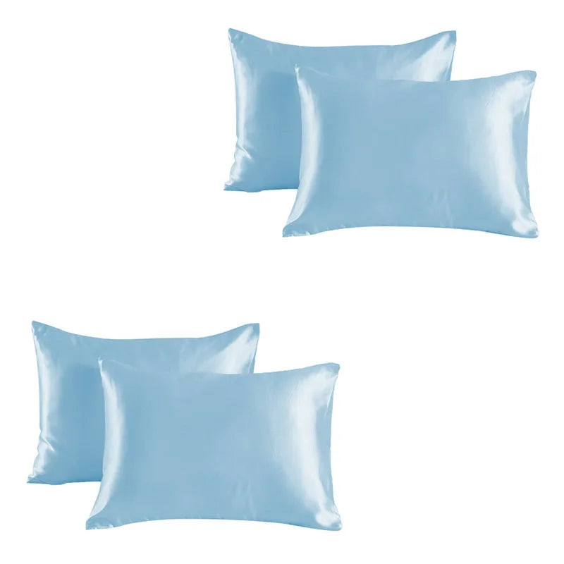 A set of light blue satin silk pillowcases, including two standard-sized pillows.