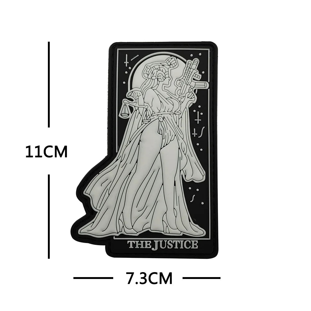 A black silhouette of a female figure with flowing hair and a sword, labeled The Justice, on a rectangular patch.