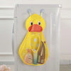 A yellow cartoon duck mesh bath toy organizer hanging on a white cabinet door with adhesive hooks.