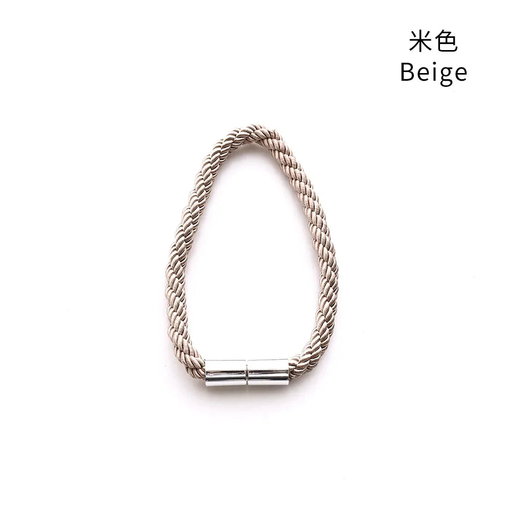 A beige braided magnetic curtain tieback clip.