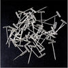 Assorted stainless steel T-pins used for wig making and knitting, scattered on a dark surface.