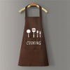 A brown waterproof oil-proof PVC kitchen apron with a pocket and the word COOKING printed on it, hanging on a wooden hanger.