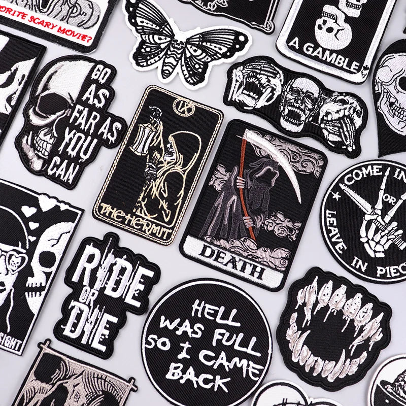 A collection of black and white embroidered skull patches featuring various themes like death and skulls.