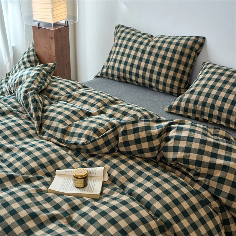 A plaid duvet cover set in olive green and beige tones with a checkered pattern displayed on a bed.