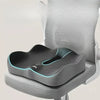A gray ergonomic memory foam seat cushion is placed on a light gray chair seat.