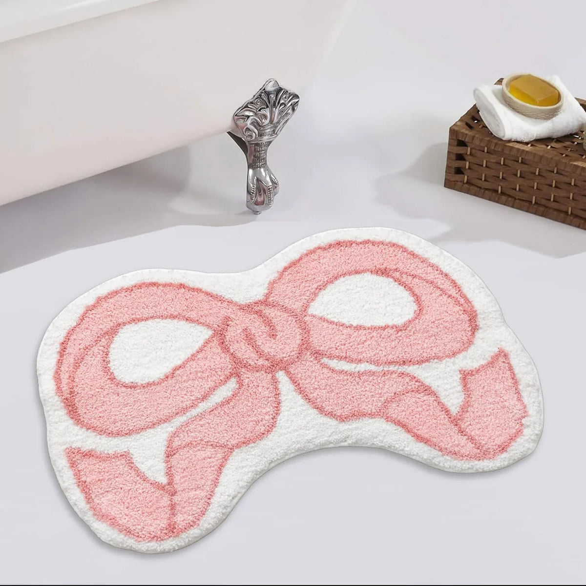 A pink fluffy decorative rug shaped like a bow is displayed next to a silver figurine.
