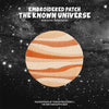 Embroidered patch featuring a striped orange and cream planet against a dark starry background.