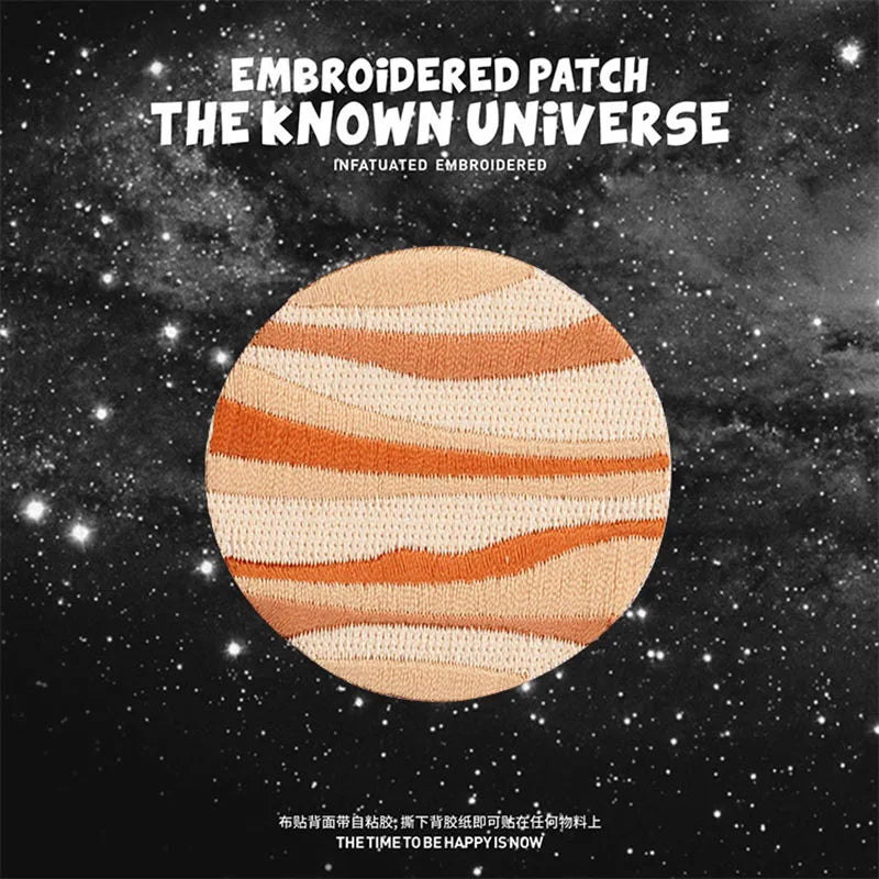 Embroidered patch featuring a striped orange and cream planet against a dark starry background.