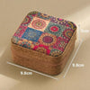 A rectangular storage box with a woven texture and a colorful patchwork lid featuring floral and geometric patterns.