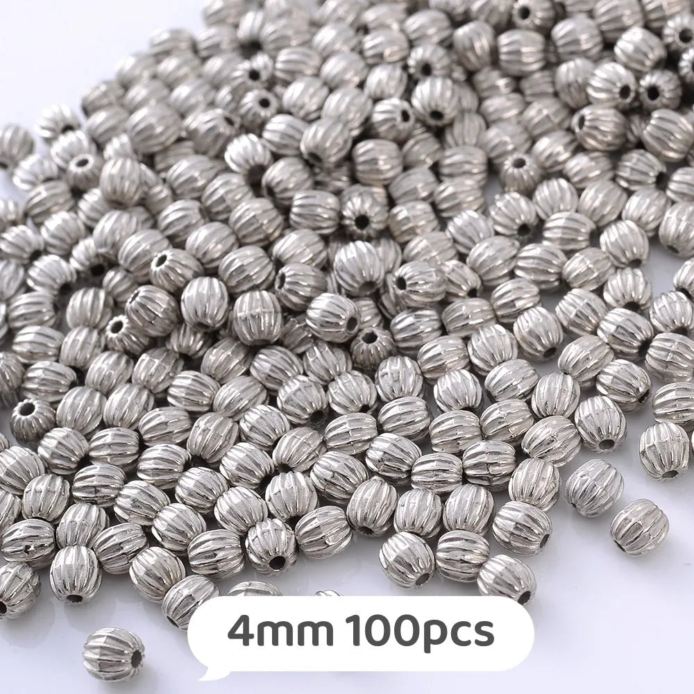 A pile of silver metallic geometric beads, 4mm size, for jewelry making.