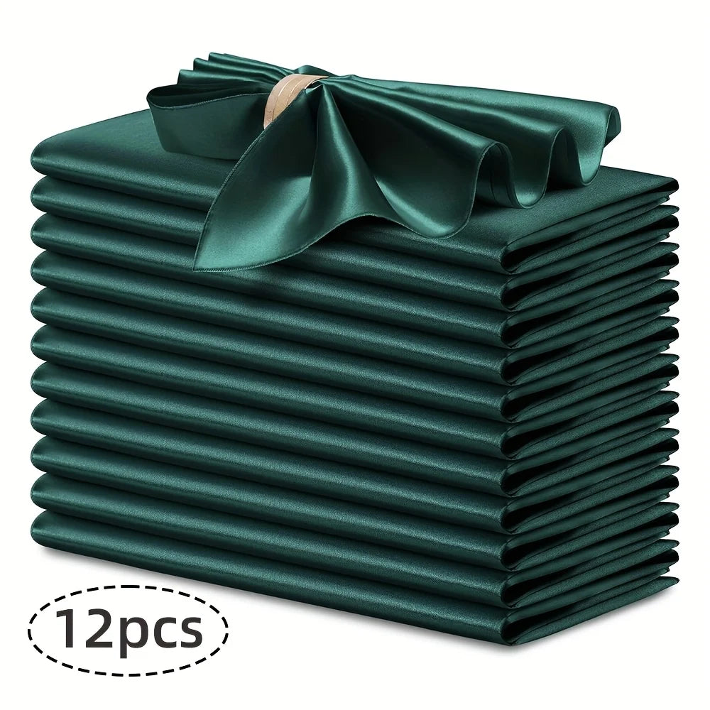 A stack of twelve dark emerald green silky satin dinner napkins with a decorative bow.
