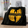 Black flannel throw blanket featuring a large yellow stylized text design on a white shelf.