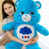 A blue Care Bears Rainbow Bear plush toy with a smiling face and soft texture.