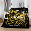 A black throw blanket featuring a yellow and white graphic design with stylized skulls and lettering.