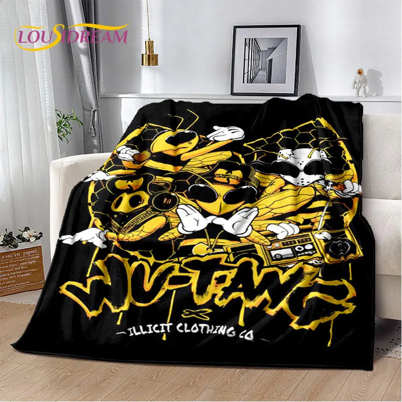 A black throw blanket featuring a yellow and white graphic design with stylized skulls and lettering.