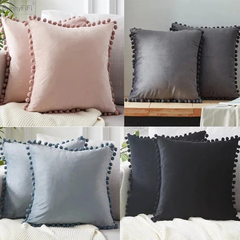 A collection of velvet decorative cushion covers in shades of pink, gray, and black with beaded trim.