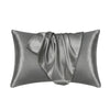 A smooth, gray satin silk pillow cover is shown folded and draped.
