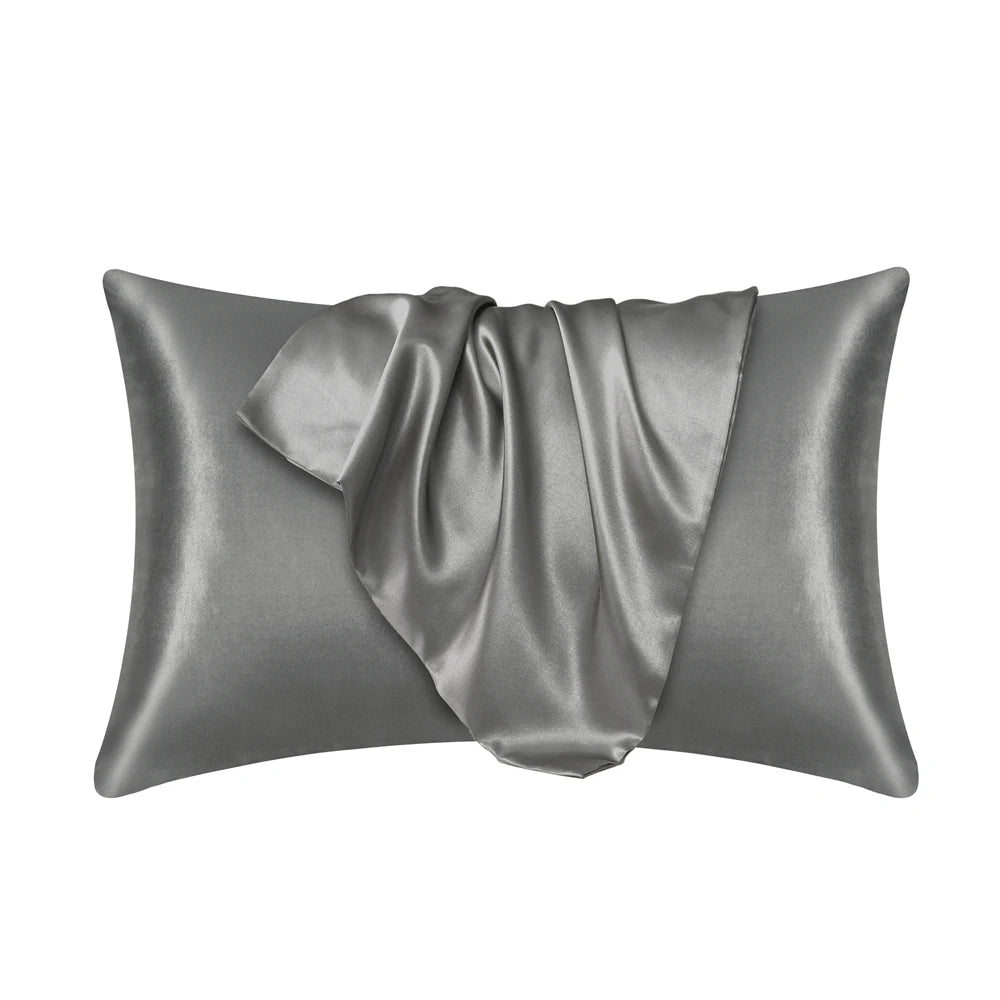 A smooth, gray satin silk pillow cover is shown folded and draped.