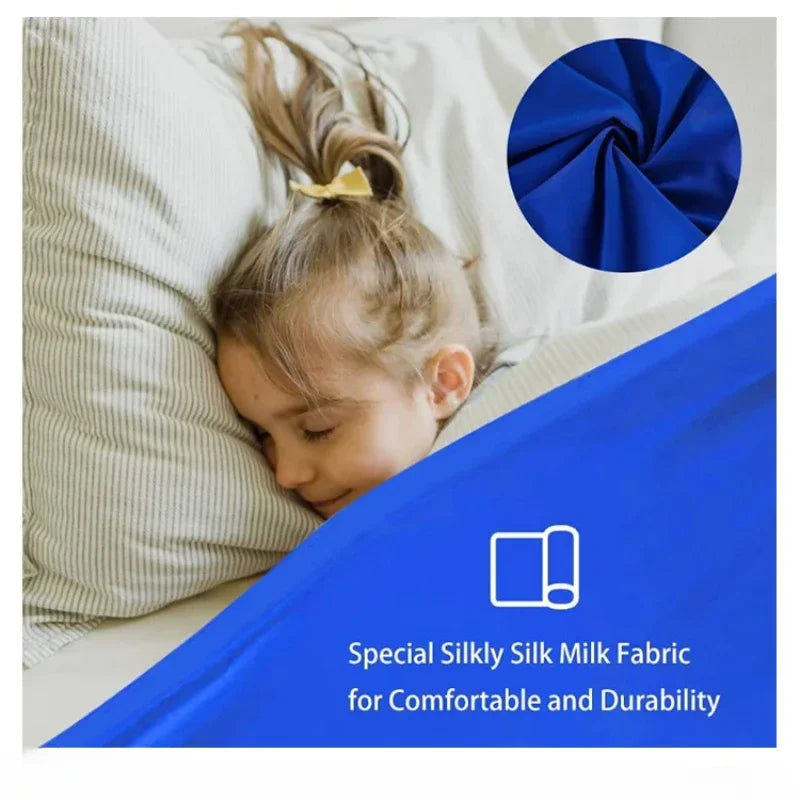 A child is lying on a bed with a blue fabric and a dark blue circular swatch of silk fabric.