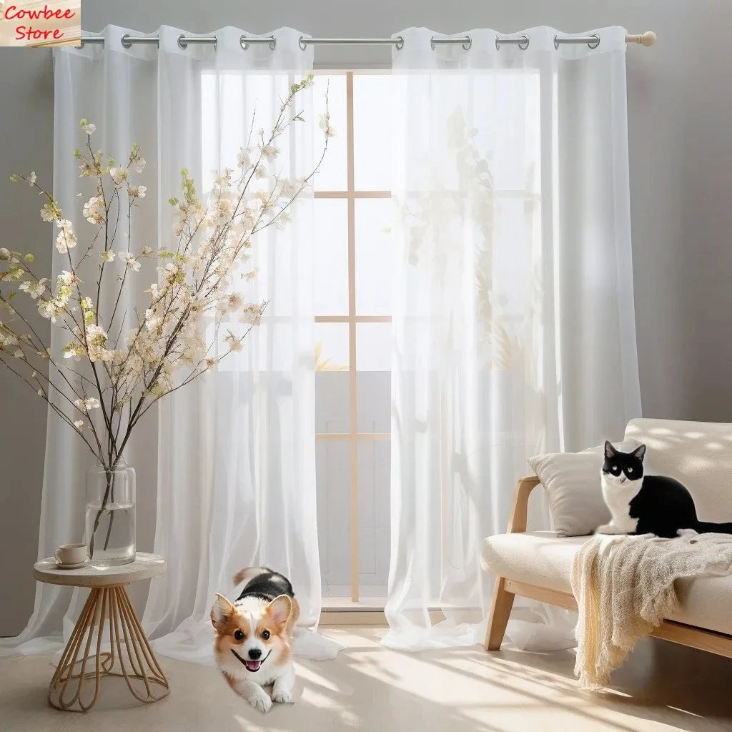 Semi-sheer white tulle curtains with floral texture hanging in a bright room.