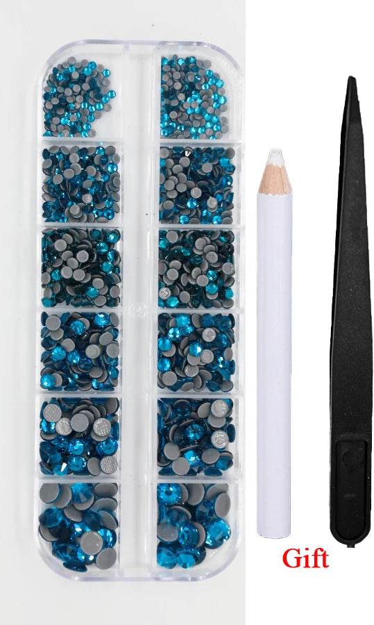 A clear plastic container holds various blue and silver crystal hot fix rhinestones and an applicator tool.