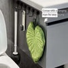 A leaf-shaped absorbent microfiber towel hanging on a kitchen cabinet door with a rope for drying.