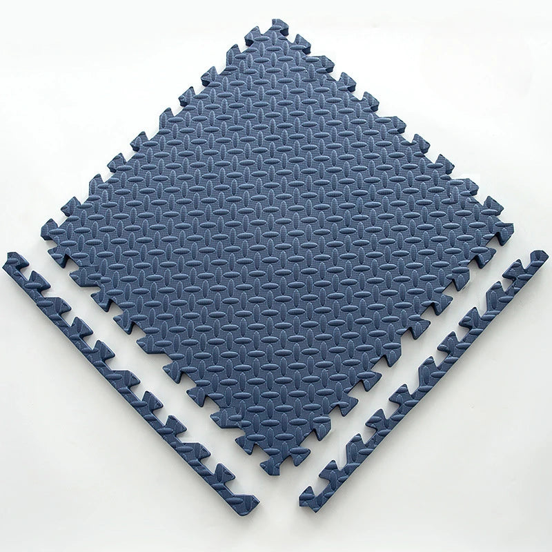 A blue interlocking foam play mat with a diamond pattern, shown from above.