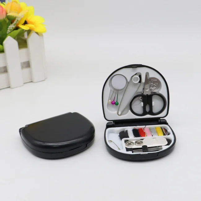 A black portable DIY sewing box with various tools and needles inside, next to a yellow flower arrangement.
