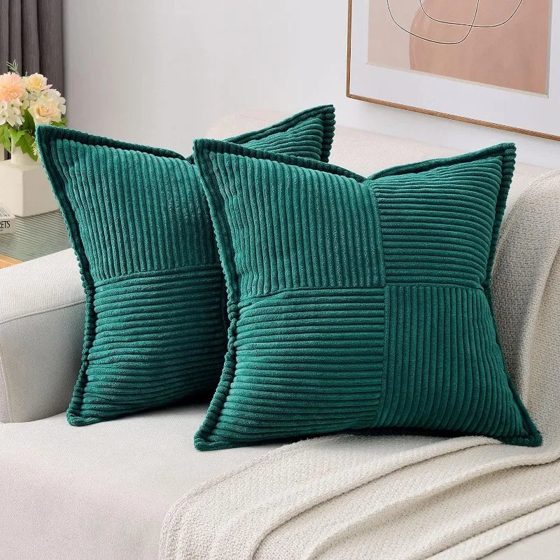 A set of deep teal striped corduroy lumbar support pillows resting on a light-colored fabric.