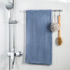 A blue towel is hanging on a metal rack next to a shower fixture.