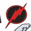 A black circular embroidered patch featuring a red lightning bolt design on a white background.