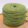 A ball of olive green craft yarn for knitting and DIY displayed on a wooden surface.