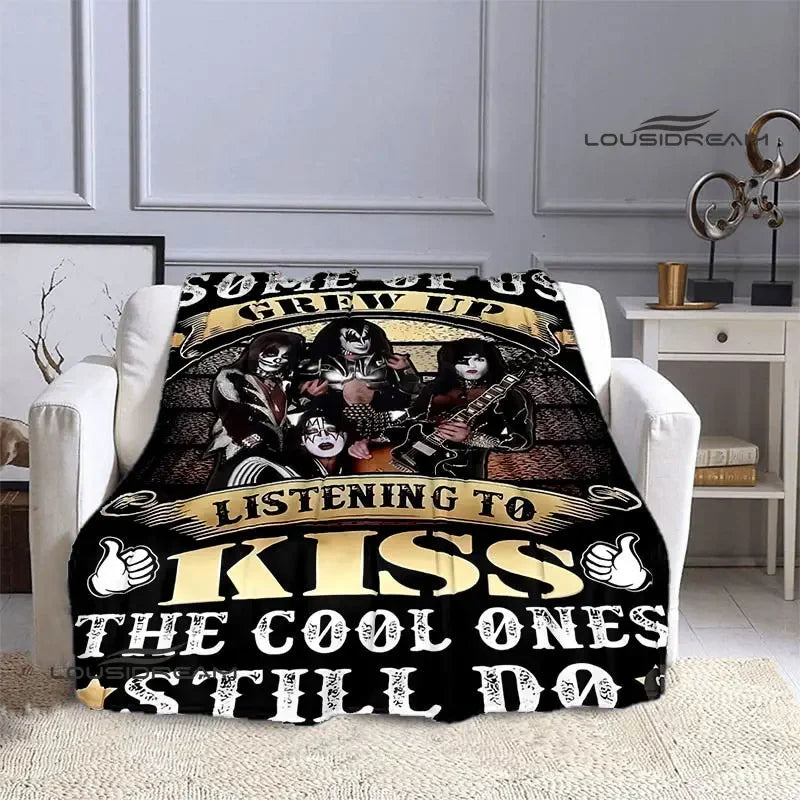A black and gold printed flannel travel blanket featuring a band graphic and text.