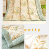 A stack of light beige and sage green quilted fabric for a soft breathable quilt.