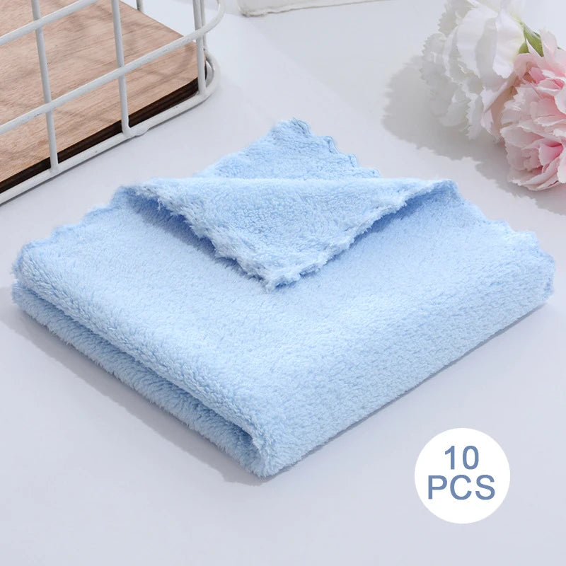 A stack of ten light blue velvet cleaning face towels placed on a white surface.