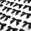 A close-up view of a black satin ribbon twist tie bow in a row against a white background.