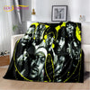 A black and yellow graphic throw blanket featuring portraits of various men.