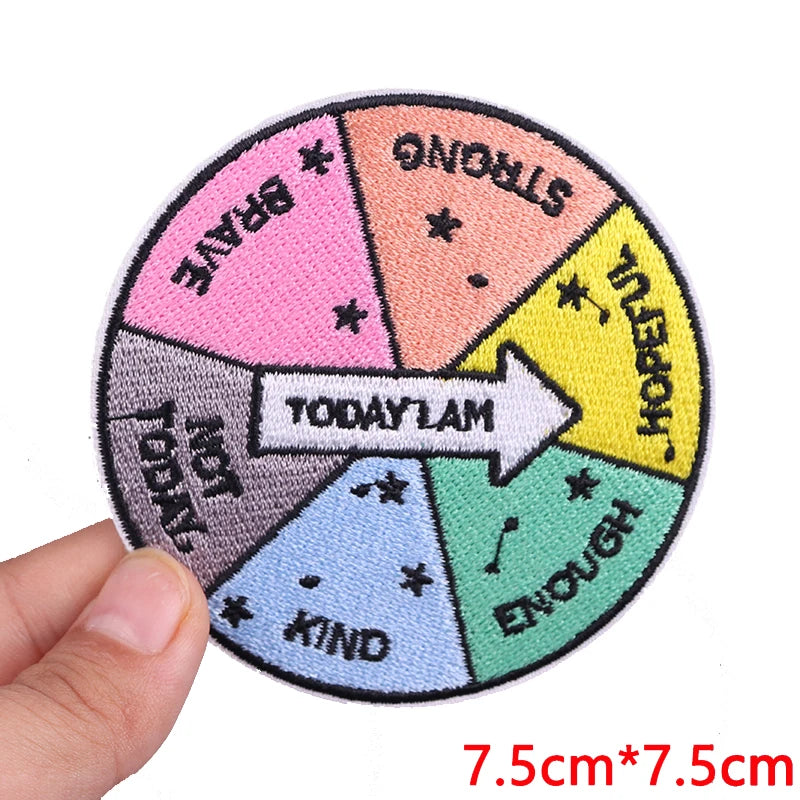 An embroidered circular patch divided into sections with words like Brave Strong Hopeful Kind and Enough