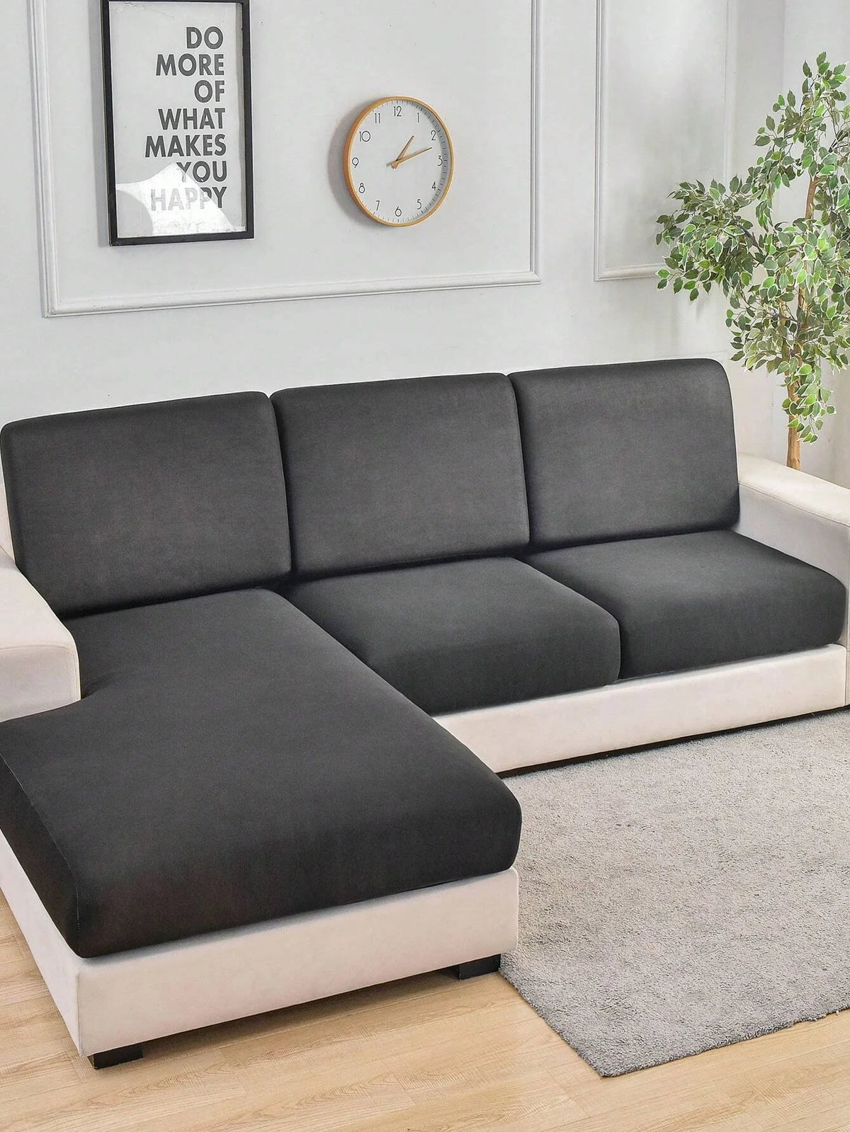 A modern gray sofa with slipcovers sits on a light rug in a bright room.