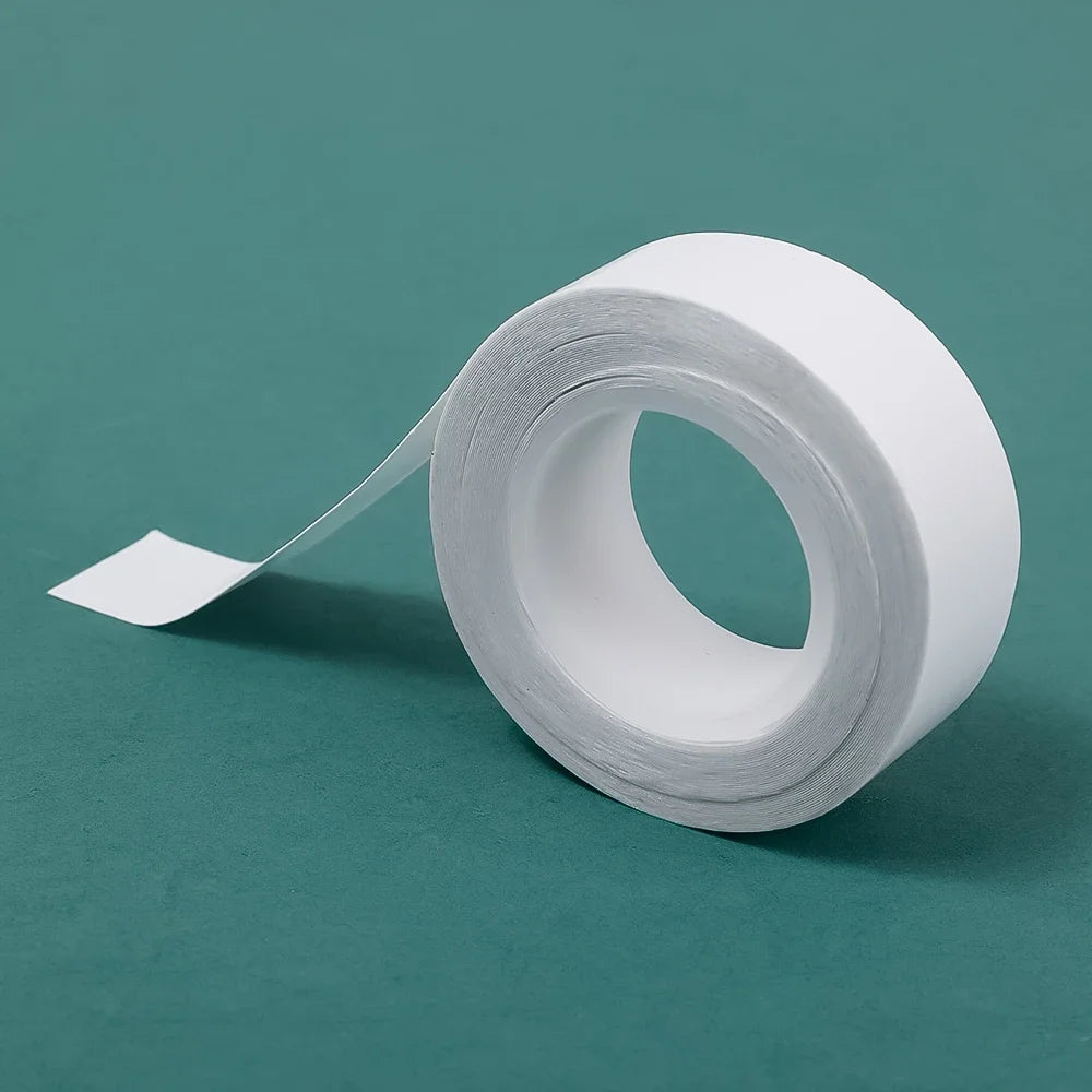 Roll of white invisible self-adhesive lingerie tape lying on a teal surface.